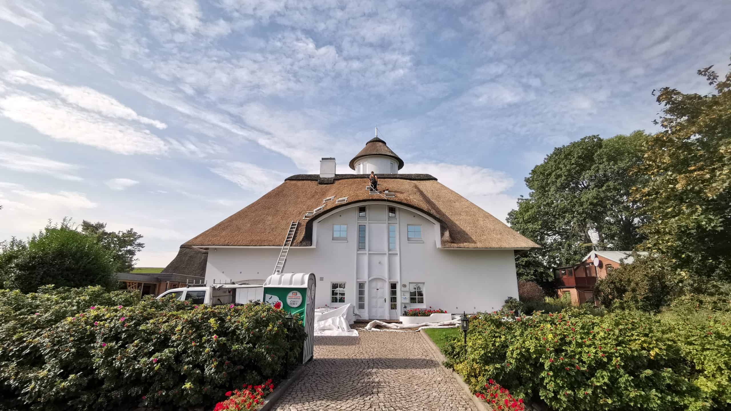 Traditionelles Reetdachhaus in der Region Steinburg mit gepflegtem Garten.