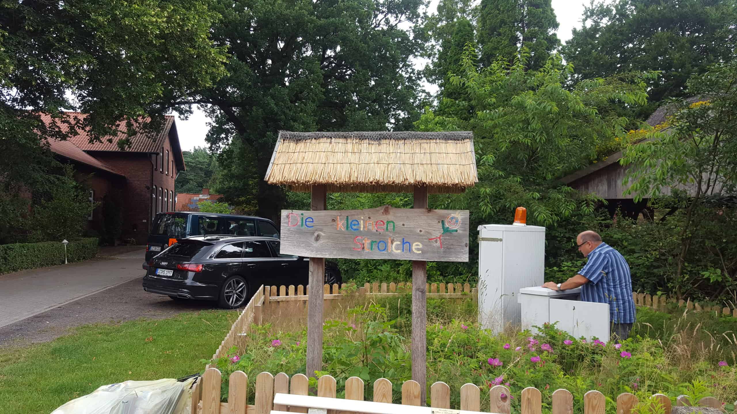 Reetdachdecker arbeitet an einem Reetdach im Garten.
